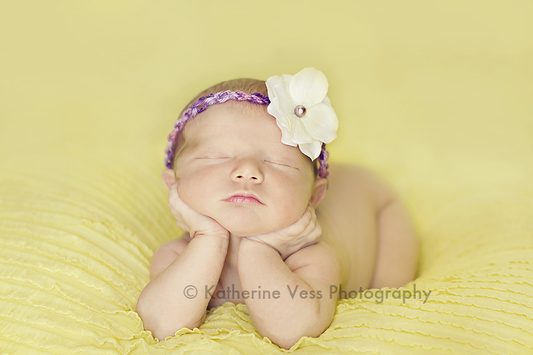 cute newborn with chin in hands pose