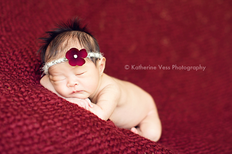 adorable baby girl on red blanket