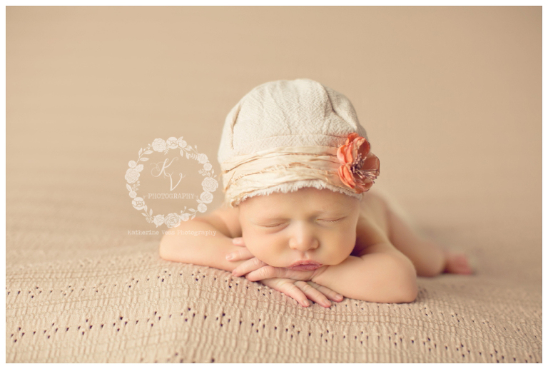 newborn girl in head up pose with hat